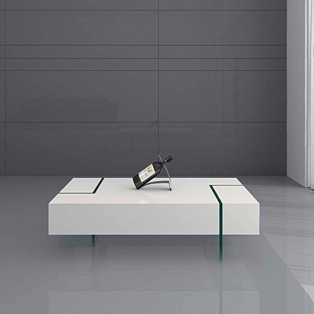 Modern white coffee table with a wine bottle holder against a gray wall.