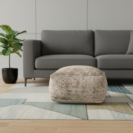 Textured ottoman in a living room setting with a gray sofa and geometric rug.