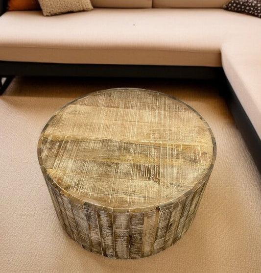 Round wooden stool with a patchwork design on a beige carpeted floor.